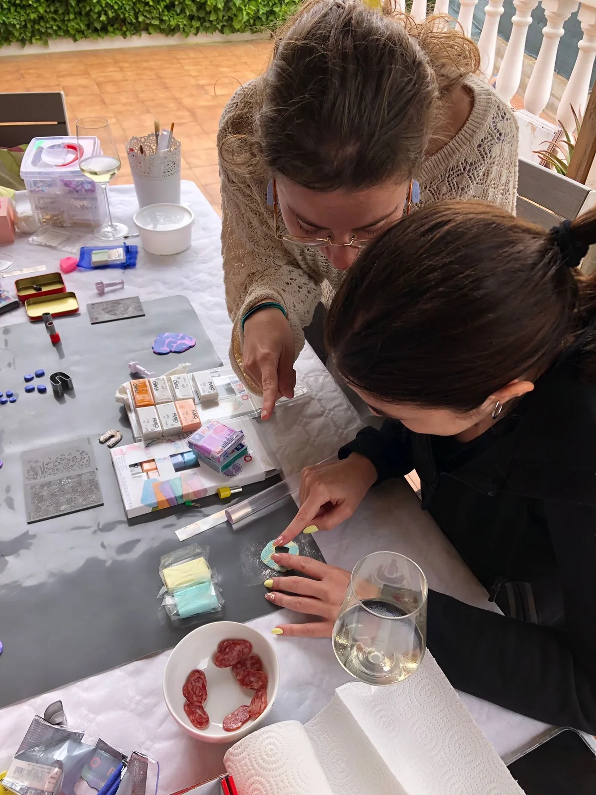 Manos trabajando piezas de arcilla polimérica en un taller Mint